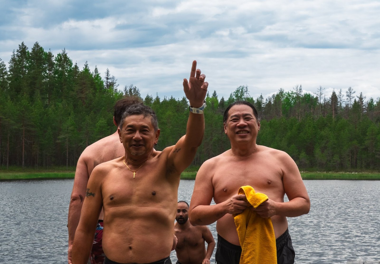 Signatories celebrating together on a lake dock after a sauna